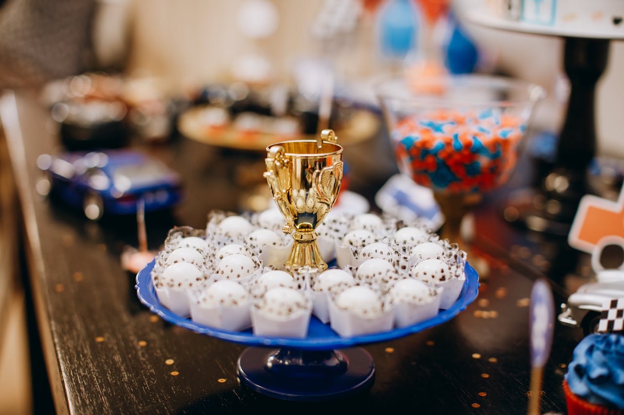 Colorful display of sweets and a trophy centerpiece at a festive event indoors.